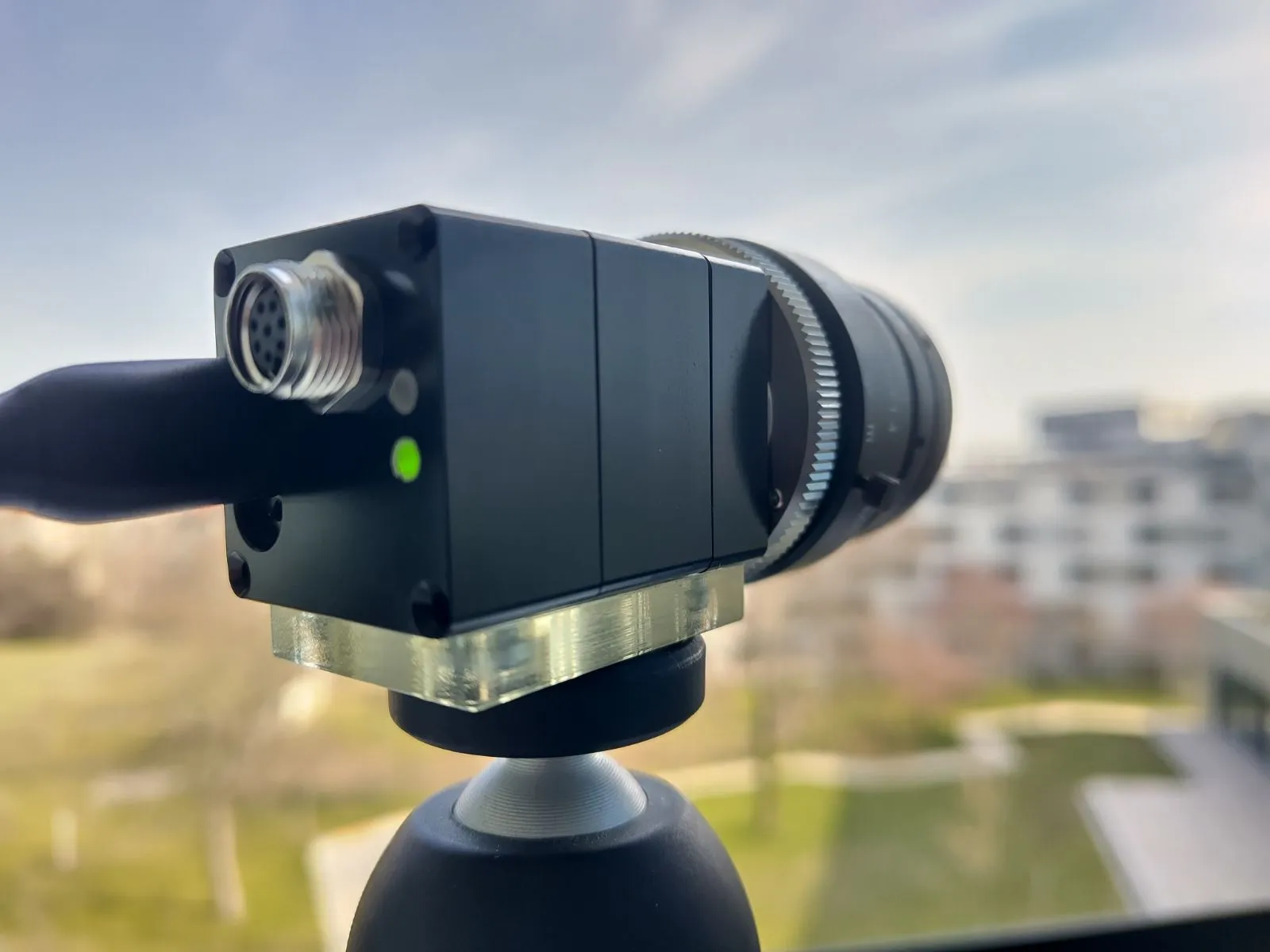 HSCAM NANO prototype camera mounted on a tripod, outdoor test photograph.