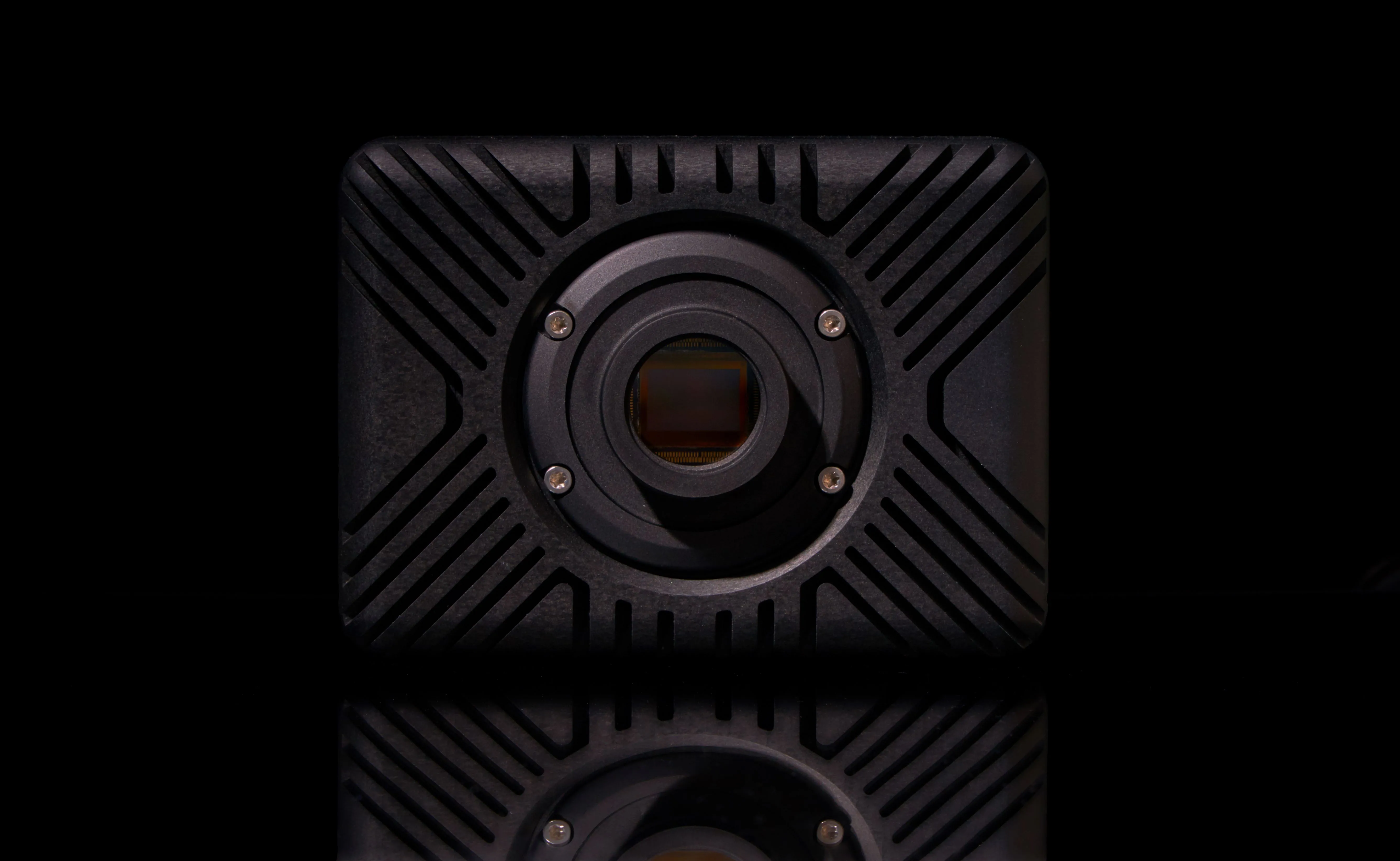 Front view of an HSCAM STREAMER camera with the lens removed, showing the exposed image sensor at the center of the housing, studio photograph.